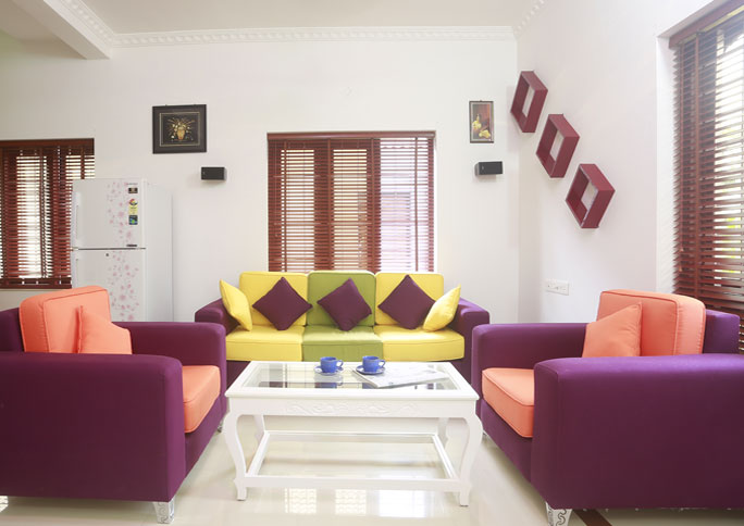 Living room with purple armchairs and a yellow-green sofa